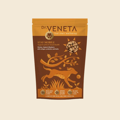 A stand-up pouch of Dr. Veneta Stay Mobile dog food, featuring a brown and golden-yellow design with an illustration of a running dog and a bone, set against a solid cream background.