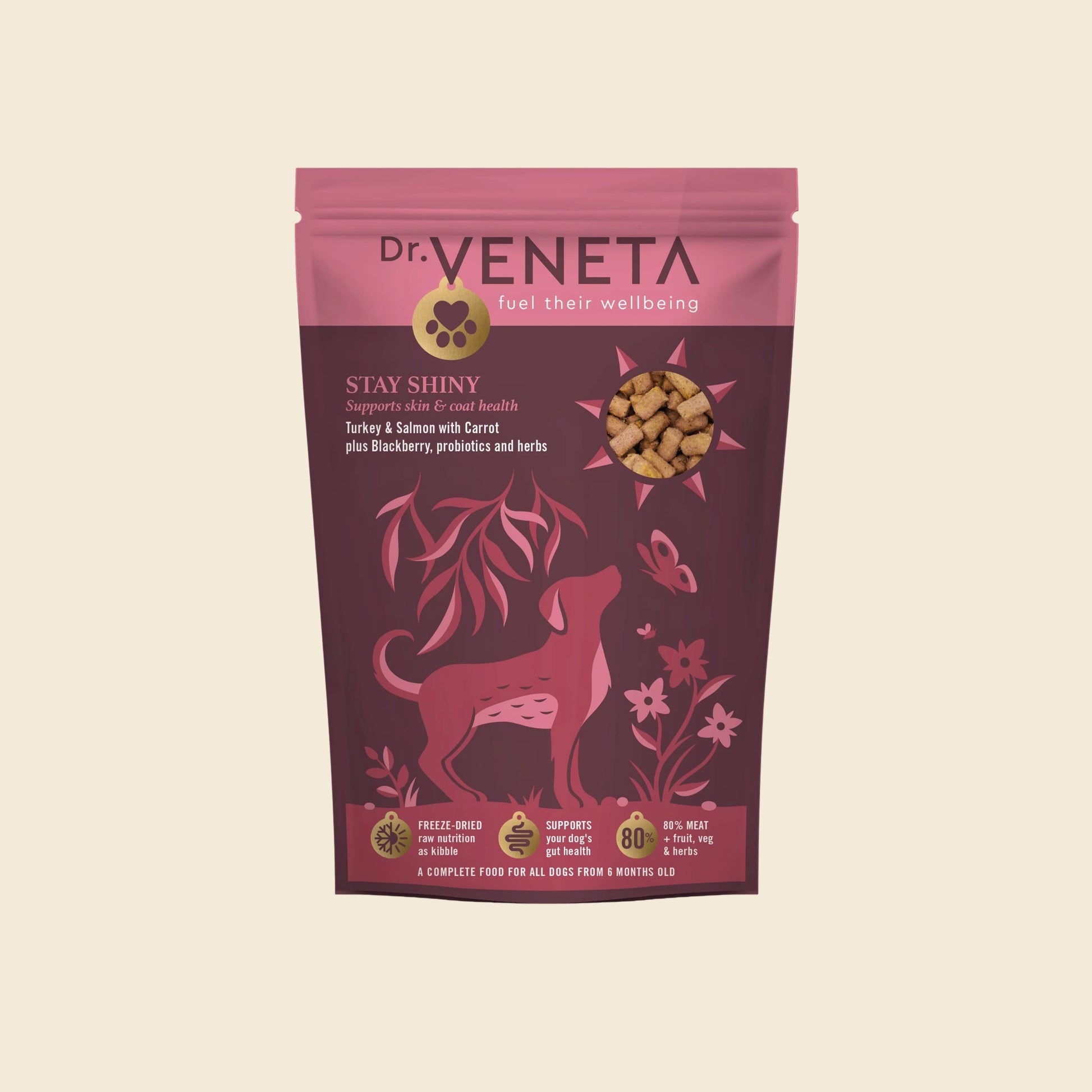 A stand-up pouch of Dr. Veneta Stay Shiny dog food, featuring a pink and dark magenta design with a dog silhouette and a clear window showing the kibble inside, set against a solid cream background.